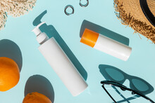 Bottles Of Cosmetics Cream And Summer Accessories On Blue Background