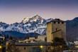 Aosta, sunset on the medieval tower with the snow-capped mountains on the background 