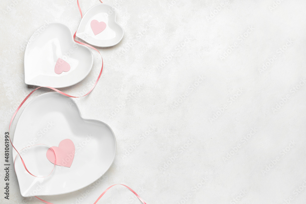 Beautiful heart shaped plates for Valentine's Day on white background