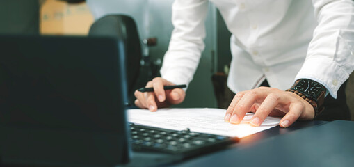 Wall Mural - Smart businessman working on document on his desk, planning analyze investment and marketing on tablet in office.