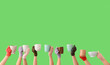 © Pixel-Shot - Women in warm gloves with cups on green background