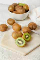 Wall Mural - Board with fresh ripe kiwi on light background, closeup