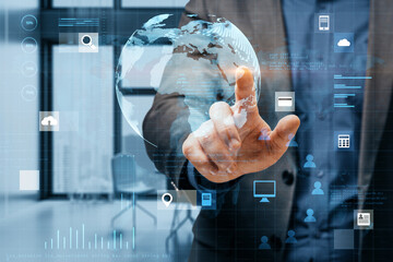 Poster - Close up of businessman hand pointing at abstract digital social globe grid hologram on blurry office interior background. Technology, data, information and connection concept. Double exposure.
