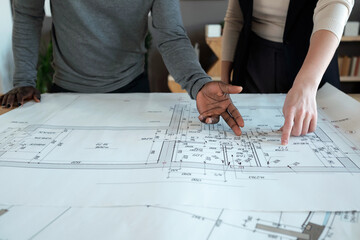 Poster - Hands of two intercultural architects pointing at sketch representing new project of construction or city district