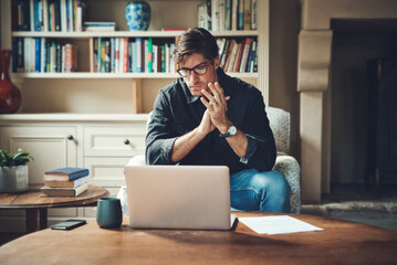 Canvas Print - Conjuring up a plan for success. Shot of a handsome young businessman working on a laptop in his office at home.