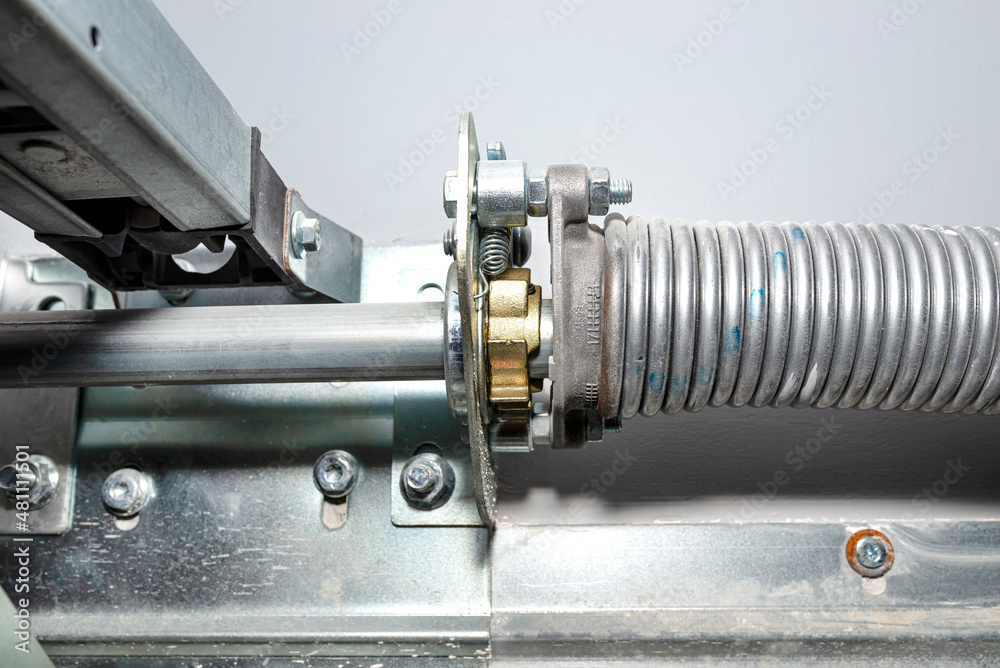 Springs tensioning the garage door mechanism, visible spring with a ...