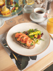 Wall Mural - Avocado toast - sandwich with guacamole and salmon fish on bread. Breakfast dish menu served in restaurant background 