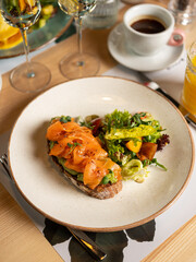 Wall Mural - Avocado toast - sandwich with guacamole and salmon fish on bread. Breakfast dish menu served in restaurant background 