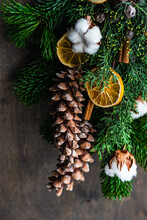 Festive Christmas Decoration With Fir Branches, Pinecones, Cotton, Orange And Cinnamon