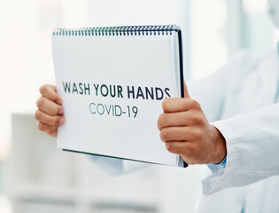 Poster - Practicing hand hygiene helps. Shot of a scientist holding a sign with wash your hands on it in a laboratory.