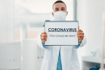 Poster - It can strike anyone at anytime. Shot of a scientist holding a sign with CORONAVIRUS-YOU COULD BE NEXT on it in a laboratory.