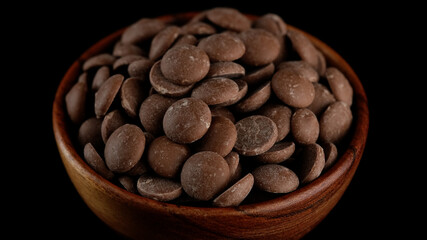 Wall Mural - Milk chocolate chips in wooden bowl. Confectionery concept