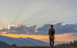 Travel young girl with backpack and hat enjoying sunset on peak mountain. Tourist traveler on background valley landscape view mockup. Rear view