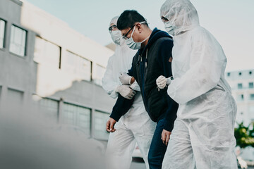 Poster - Follow us for a Covid-19 test. Shot of a young man getting taken away by healthcare workers in hazmat suits during an outbreak.