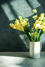 Bunch Of Narcissus Flowers In A Vase Casting Shadows On A Table