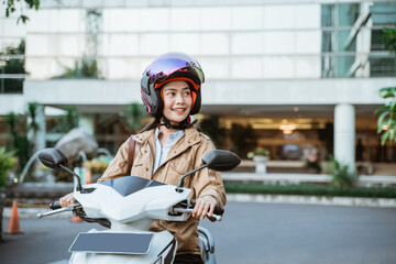 Beautiful woman wearing a helmet while riding a motorcycle