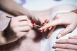 © inesbazdar - Close up image of manicure process, removal of  excess skin on the nail with a special tool. Focus on fingernail.
