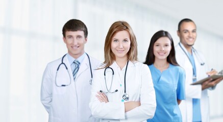 Poster - Portrait of happy young nurse in uniform with healthcare team in background. Successful doctor and nurses