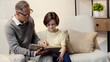 © LIGHTFIELD STUDIOS - middle aged grandfather in glasses holding book near grandson at home