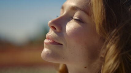 pretty red hair girl with closed eyes dreaming with smile in summer day outside.