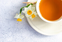 Overhead View Of A Cup Of Green Tea With Fresh Narcissus Flowers