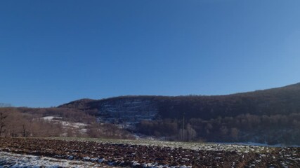 Wall Mural - Winter nature landscape , hills and forest with snow. View from car in motion.