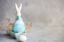 Painted Easter Egg And Easter Bunny Decorations On A Table With Dried Flowers