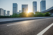 Asphalt Road And City Skyline With Modern Commercial Office Buildings In Shenzhen At Sunrise, China.