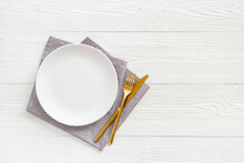 Empty Tableware With Tablecloth Top View. Plate With Fork And Knife On Napkin