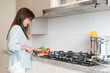 © ADDICTIVE STOCK - Woman cutting tomatoes on counter