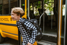 White Boy With Backpack Smiling While Getting Off School Bus
