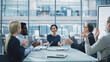 © Gorodenkoff - Modern Office Meeting Room: Beautiful Asian Executive Director Sits in the Head of the Conference Table and Talks to a Group of Businesspeople, Managers and Investors. People Applaud.