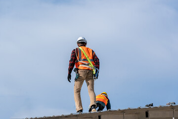 Roofer worker installing new roof on top of the ,Concept of residential building under construction.