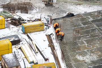 aerial top view of city construction site. tower cranes for building of new apartments under snow in winter