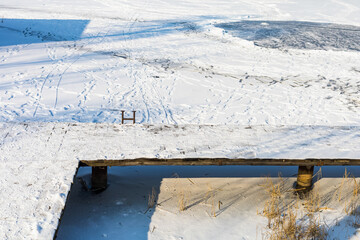 Wall Mural - Frozen lake or body of water in the winter snowy season. Background