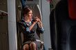 © Kostiantyn - Female flight attendant fastening seatbelt in airplane
