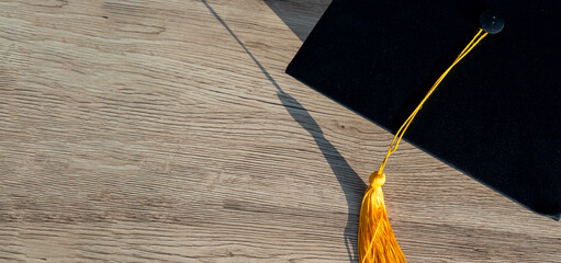 Wall Mural - Black Graduation Hat placed on wood background,concept of education for the future university life.