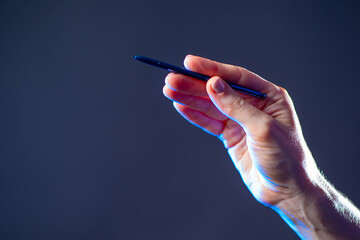 Poster - Hand holding pen isolated on grey background. Business woman hand using stylus pen. Paperless office, e-signing, electronic signature. Isolated hand with electronic stylus.