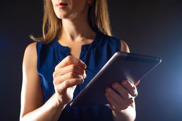 Poster - Woman using laptop. A woman with an electronic tablet and a stylus. Female professional drawing with stylus pen on digital tablet. Electronic gadgets. Girl with laptop on dark background.