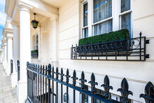 Pimlico, London Terraced Row House Building White Columns Exterior Old Vintage Historic Traditional Architecture And Window With Metal Fence Railing