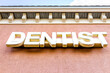 Sign for Dentist word in big letters low angle view looking up at entrance to strip mall building and nobody