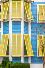 Seaside, Florida Pastel Blue And Yellow Painted Colorful Hurricane Open Window Shutters Architecture Exterior Of Modern New Urbanism Vintage Style House Home Cottage