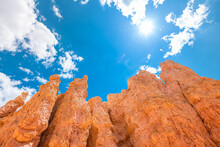 Landscape Low Wide Angle View Looking Up Of Hoodoos Orange Rock Formations And Sun In Blue Sky At Bryce Canyon National Park In Utah Queens Garden Navajo Loop Trail