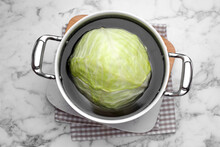 Sauce Pan With Hot Water And Cabbage For Preparing Stuffed Rolls On White Marble Table, Top View