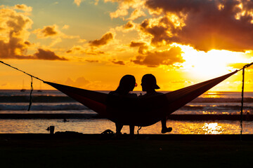 Silhouette of Couple in Hammock Watching Sunset