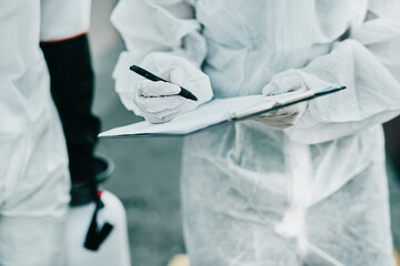Poster - Healthcare workers hard at work. Shot of healthcare workers wearing hazmat suits working together to control an outbreak.