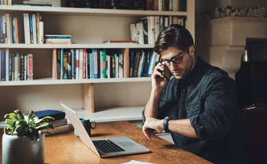 Canvas Print - Time isn't on my side today. Shot of a handsome young businessman making a phone call while working in his office at home.