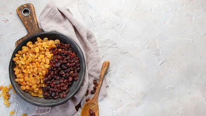 Wall Mural - Golden and brown raisins on light  background. Dried Fruits. Top view, flat lay, copy space