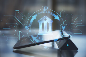 Poster - Close up of tablet on desktop with abstract online banking hologram on blurry background. Money, technology and trade concept. Double exposure.