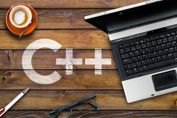 Poster - C plus Programming Language. Word c++  on wooden desk and laptop
